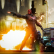 Jason "Red Hood" Todd strikes a cool pose in front of an explosion, shooting his gun off-screen (probably) at some bad guys.